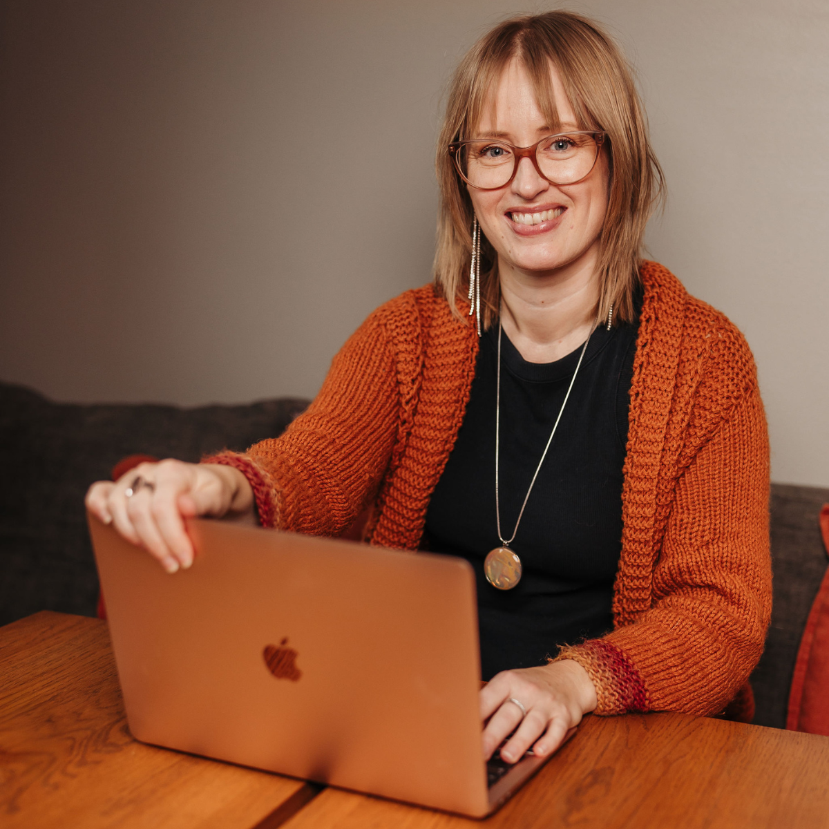 anna sitter framför datorn, tittar in i kameran och håller en hand på datorn som om hon ska stänga ner den